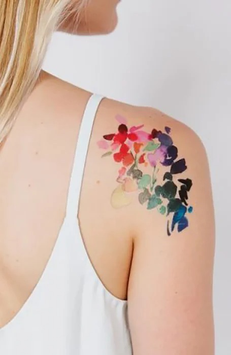 tatuaje de flor de colores en el hombro de mujer