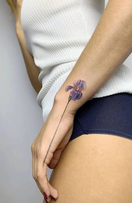 tatuaje de flor violeta en la muneca